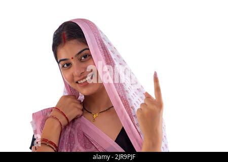 Close-up portrait of a Bihar woman pointing above against white background Stock Photo