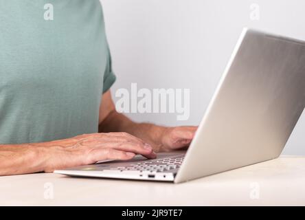 Man hands closeup typing on laptop keyboard. Using computer for work, study, relax. Male preparing project, report, writing e-mail or surfing Internet. High quality photo Stock Photo