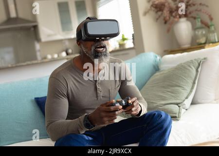 Senior african american man playing video games and using vr headset Stock Photo
