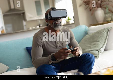Senior african american man playing video games and using vr headset Stock Photo