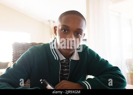 Portrait of african american male teenager learning and holding pen Stock Photo