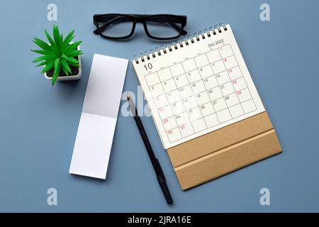 October 2022 desk calendar with notepad on blue background. Copy space. Stock Photo