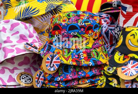 Colourful display of hats with emojis and Union Jack badges on sale, UK Stock Photo