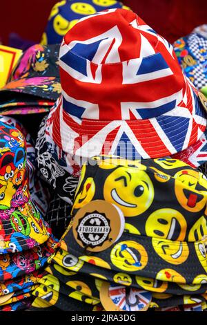 Colourful display of hats with emojis and Union Jack badges on sale, UK Stock Photo
