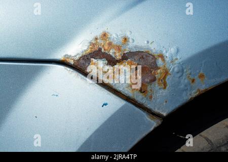 rust and paint bloating on the fender of the car Stock Photo