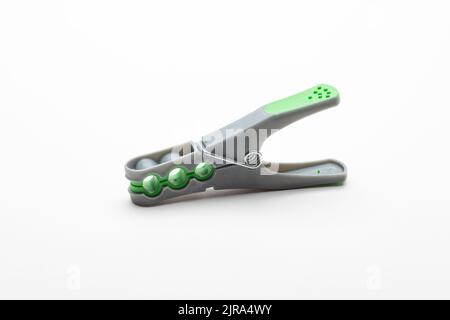 Grey plastic clothespin with green grip, isolated on white background Stock Photo