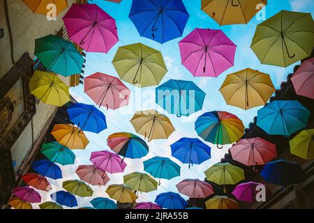 Colorful umbrellas background. Colorful umbrellas hanging in the sky used as street decoration. Stock Photo