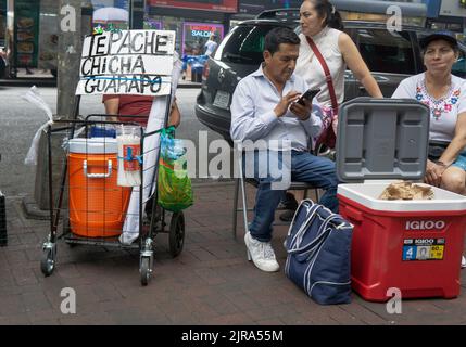 A street scene on Roosevelt Ave. in Corona including selling a cold spicy drink, Tepache Chicha Guarapo, likely pineapple flavor. In Queens, New York. Stock Photo