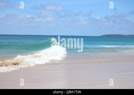 Perfect waves in cristaline waters beside Two Brothers Cliff, Cacimba beach, Fernando de Noronha island, Brazil Stock Photo