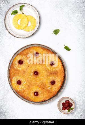 Delicious pineapple upside down cake with candied cherries. Summer tropical dessert. Top view. Copy space. Stock Photo