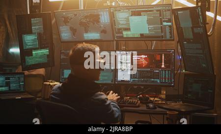 Cybercriminal in virtual reality glasses hacking and launching a nuclear missile by countdown using a computer with software in an illuminated modern hacker hideout Stock Photo