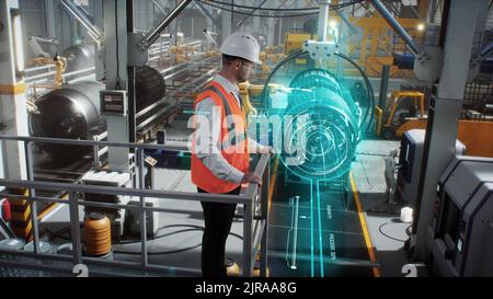 An engineer on a high-tech robotic line for the production of aerospace engines controls information using a modern innovative graphical interface. Stock Photo