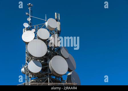 Antenna communication technology on blue sky with copy space. Communication tower connect to data of smart city. Satellite dish telecommunication 5G. Stock Photo