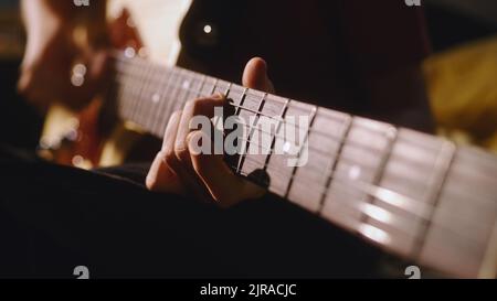 Soft focus of unrecognizable teen musician playing electric guitar during rehearsal at home Stock Photo