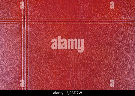 Natural, artificial red leather texture background with decorative seam. Material for sport items, clothes, furnitre and interior design. ecological f Stock Photo
