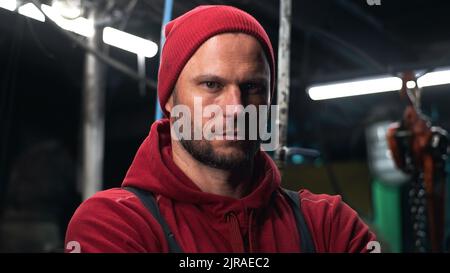 Serious man crossing arms and looking at camera while standing near colleagues in fishing ship Stock Photo