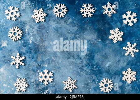 Christmas or winter composition with frame. Banner made of snowflakes on blue background. The concept of Christmas, New Year, holidays, holidays, copy space or wallpaper for your design. Flat lay. Stock Photo