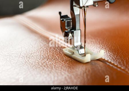 Leather sewing machine in action in a workshop with hands working on a  shoulder bag Stock Photo - Alamy