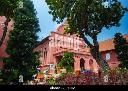 Malacca, Malaysia - August 10, 2022: Christ Church in the center of Melaka. Oldest functioning Protestant church in Malaysia. Past the trees and flowe Stock Photo