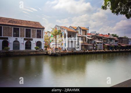 Malacca, Malaysia - August 10, 2022: Along the Melaka river with the old brightly painted houses. Bars and restaurants line the course of the river. L Stock Photo