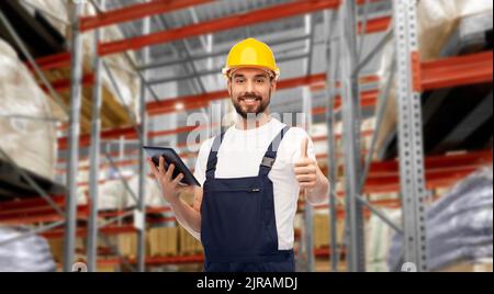 loader with tablet pc shows thumbs up at warehouse Stock Photo