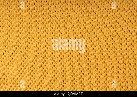 Yellow color knitting wool texture. Close up background of knitted fabric with dots pattern Stock Photo