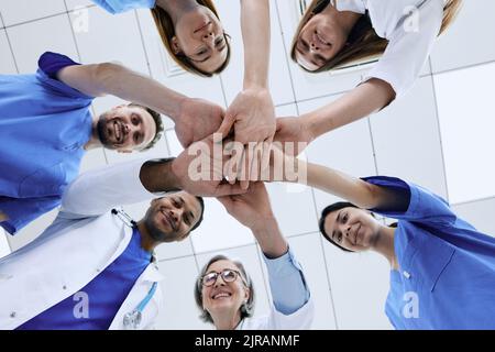 Bottom view of multiethnic medical team putting hands together in circle for success work. patients health in doctors hands Stock Photo