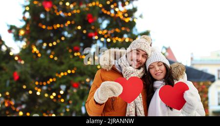 happy couple with red hearts at christmas market Stock Photo