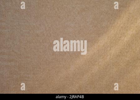 Blank beige cardboard texture with sunrays. Abstract background. Recycled paper, environmentally friendly raw materials. Stock Photo