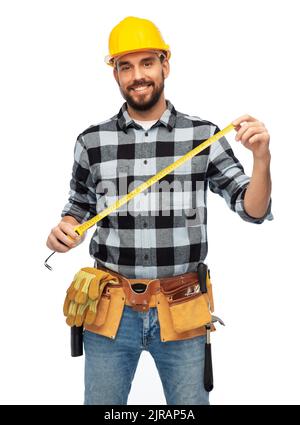 happy male worker or builder in helmet with ruler Stock Photo