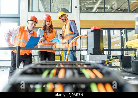Enineers in factory examining work machine Stock Photo