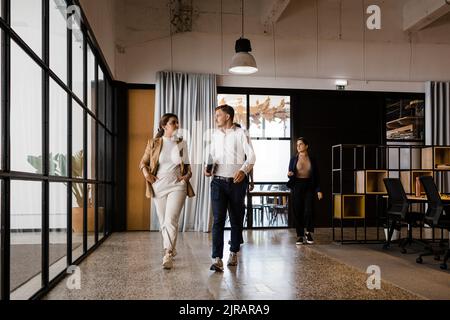 Business colleagues walking together in modern office Stock Photo