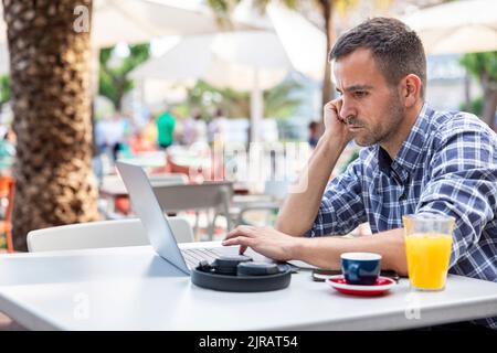 Mature freelancer using laptop sitting at cafe Stock Photo