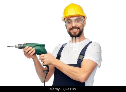 happy male worker or builder in helmet with drill Stock Photo