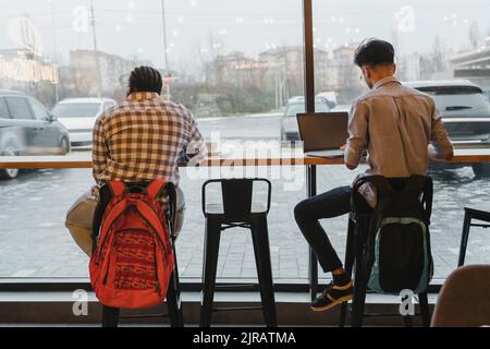 Young freelancers working at table in cafe Stock Photo