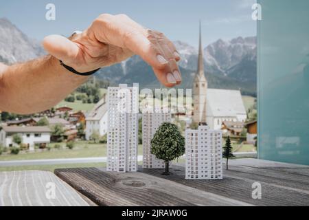 Hand of engineer over building models Stock Photo
