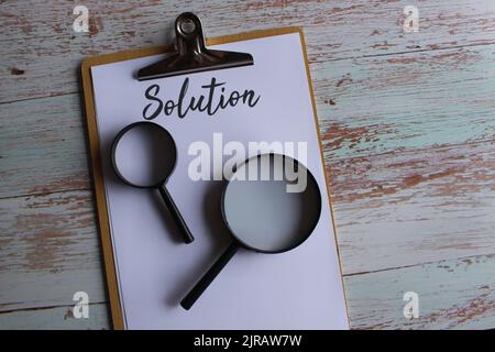 Searching for solution, finding solution concept. Magnifying glass and text SOLUTION. Stock Photo