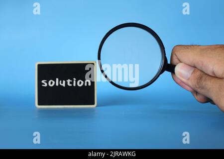 Searching for solution, finding solution concept. Magnifying glass and text SOLUTION. Stock Photo