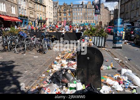 Edinburgh, Scotland, UK. 23rd  August 2022. Rubbish is seen piled on the streets of Edinburgh city centre on day six of a 12 day strike by city refuse collectors. Pic; Outdoor eating areas next to overflowing rubbish bins in the Grassmarket.  Iain Masterton/Alamy Live News Stock Photo