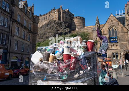 Edinburgh, Scotland, UK. 23rd  August 2022. Rubbish is seen piled on the streets of Edinburgh city centre on day six of a 12 day strike by city refuse collectors. Pic; A full but sealed bin with Edinburgh Castle to rear. Iain Masterton/Alamy Live News Stock Photo