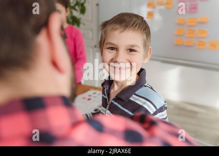 Smiling boy in front of teacher at home Stock Photo
