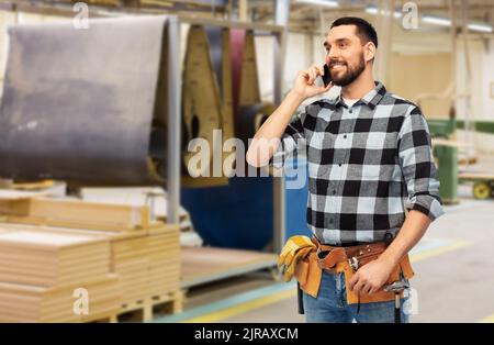 builder in helmet calling on smartphone Stock Photo