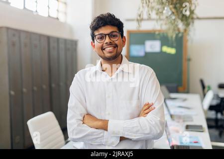 Smiling businessman with arms crossed at office Stock Photo