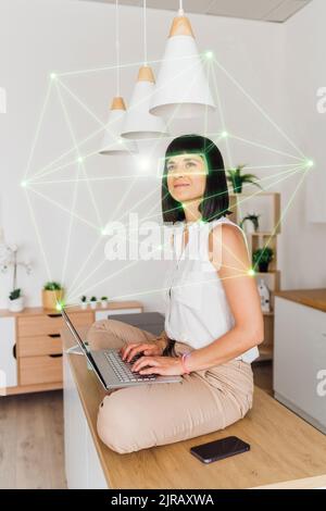 Woman at home working remotely using laptop in cyberspace Stock Photo