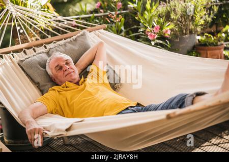 Retired senior man sleeping in hammock Stock Photo