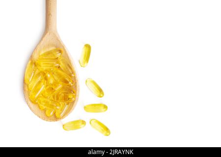 Pile of softgels capsules Omega 3 in wooden spoon isolated on white background. Close up, top view, flat lay with copy space Stock Photo