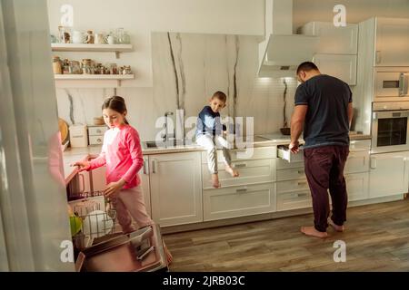 Father with children in kitchen at home Stock Photo