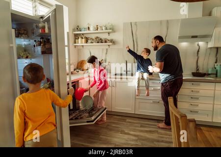 Children with father in kitchen at home Stock Photo