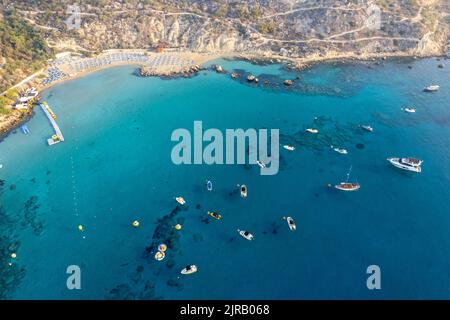 Drone aerial seascape luxury yachts moored in the coast and unrecognised people swimming and relaxing. Summer vacations konnos bay Ayia napa Cyprus Stock Photo