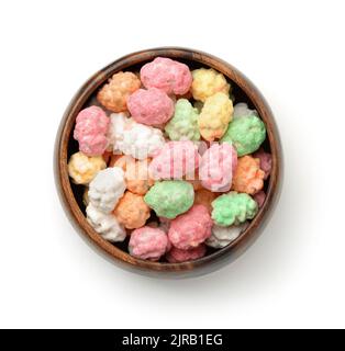 Top view of colorful sugared peanuts in wooden bowl isolated on white Stock Photo